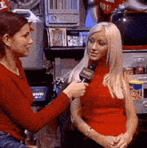 a woman in a red shirt is being interviewed by another woman in a red shirt
