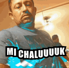 a man in a blue shirt with the words mi chaluuuk written on it