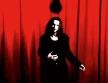 a man standing in front of a red curtain