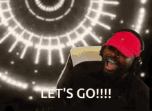 a man wearing headphones and a red hat is saying " let 's go "