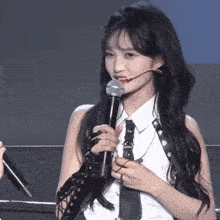 a woman with long hair is holding a microphone in her hand