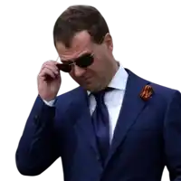 a man in a suit and tie is adjusting his glasses
