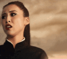 a close up of a woman 's face with a ponytail making a funny face