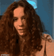 a woman with curly hair is making a funny face and has the word gifsdayrol below her