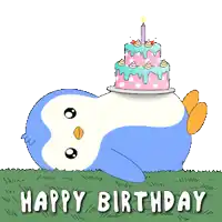 a penguin laying in the grass with a birthday cake on its head