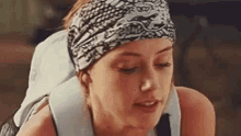 a close up of a woman wearing a headband .
