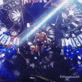 a man stands on a stage in front of a sign that says ' tiffanyluv24 '