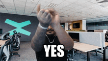 a man giving a thumbs up in an office with the word yes written on the bottom