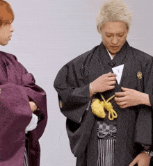 a man in a kimono is holding a piece of paper with the letter y on it