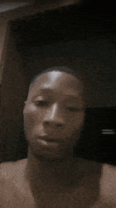 a shirtless man is looking at the camera with a serious look on his face