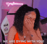 a woman is covering her face with her hand while laughing .