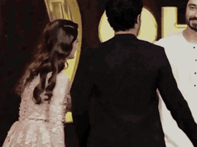 a man in a suit and a woman in a dress are standing next to each other