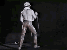 a man is singing into a microphone while standing on a stage .