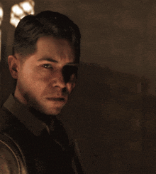 a man in a brown shirt looks at the camera with a serious look on his face