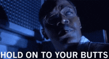 a man wearing glasses is smoking a cigarette in a dark room .