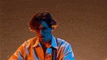 a man wearing glasses and suspenders is standing in a dark room .