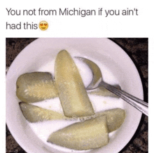 a bowl of pickles with milk and a spoon with the caption you not from michigan if you ain t had this