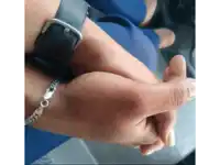 a man wearing a black watch holds another person 's hand