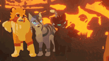 three cats are standing in front of a fire