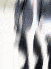 a blurry picture of a person 's feet walking on a white surface