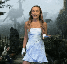 a woman in a blue and white striped dress is standing in front of a white rabbit