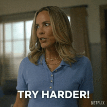 a woman in a blue shirt is saying " try harder "