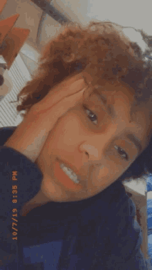 a girl with curly hair is taking a selfie with a time stamp of 9:35 pm