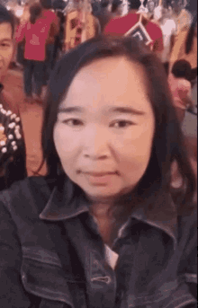a woman taking a selfie in front of a crowd of people
