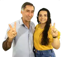 a man and a woman are posing for a picture and the man is giving a peace sign