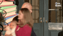 a man and a woman are standing in front of a stack of books and a sign that says " pbs news "