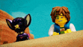 a boy and a purple monster are standing next to each other on a sandy beach