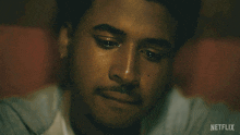 a close up of a man 's face with a netflix logo on the bottom right