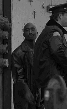 two men are standing next to each other in a black and white photo .