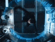 an aerial view of a man in a room with a circle of blue lights surrounding him