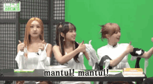 three girls are sitting at a table and one of them is saying mantul
