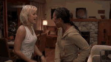 a woman with her mouth open is looking up at another woman in a room .