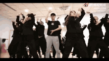 a group of people are dancing in a room with chinese writing on the ceiling .