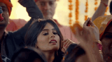 a woman is dancing in a crowd of people while a man holds her hair .