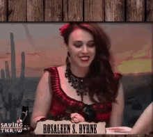 a woman sitting at a table with a sign that says rosaleen s. byrne on it