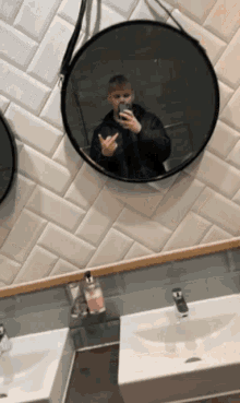 a man taking a picture of himself in a round mirror