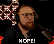 a man with a beard is wearing headphones and a microphone .