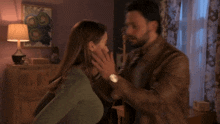 a man and a woman kissing in a bedroom