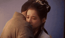 a man is hugging a woman in a traditional costume .