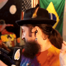 a man with a beard wearing a hat and earbuds
