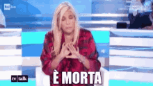 a woman is sitting on a stage with her eyes closed and says " e morta "