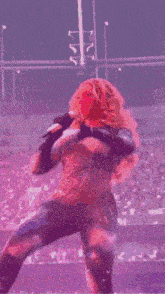 a woman singing into a microphone on a stage in front of a crowd