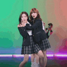 two girls in school uniforms are dancing together on a stage