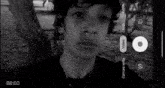 a black and white photo of a young man taking a picture of himself with a camera .