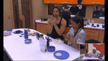 a man and a woman are sitting at a table with plates of food on it