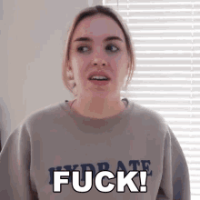 a woman wearing a sweatshirt that says " fuck " on it